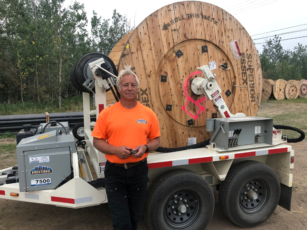 Jeff Croll front from of the spool of cable on trailer