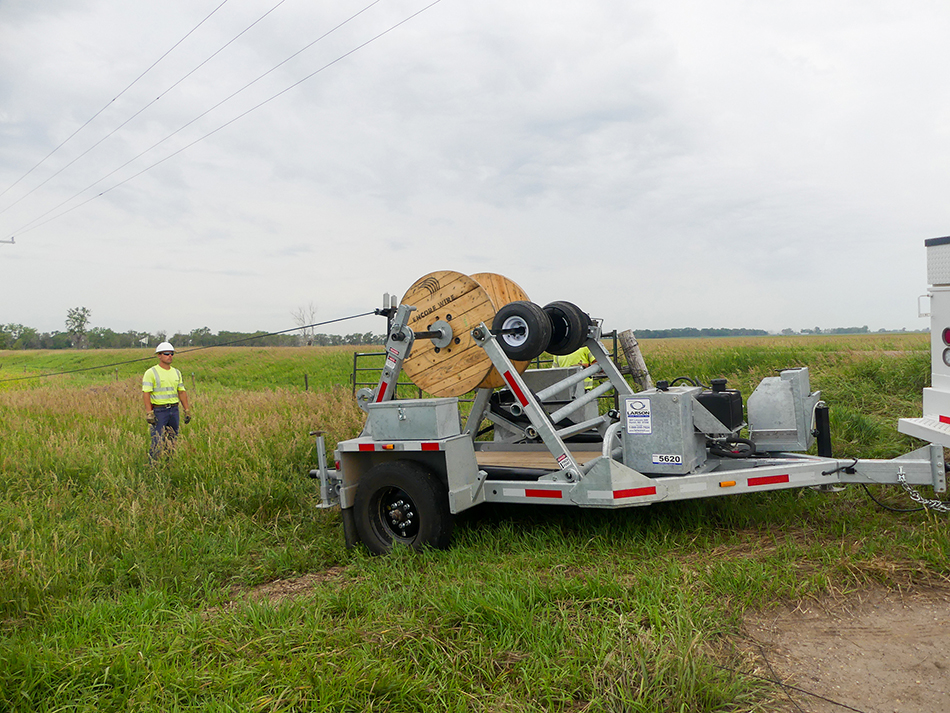 LCT-5620 trencher on a road with a worker standing nearby.