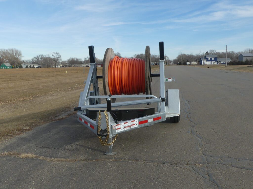 An LCT 7500 and an LRT 8R Combo trailer, with large cable spools, sitting in a lot.
